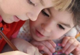 two children writing in school