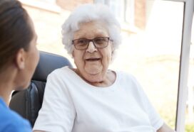 Image shows care home resident talking to a member of staff