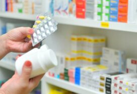 Photo shows pharmacist selecting medicines from shelf