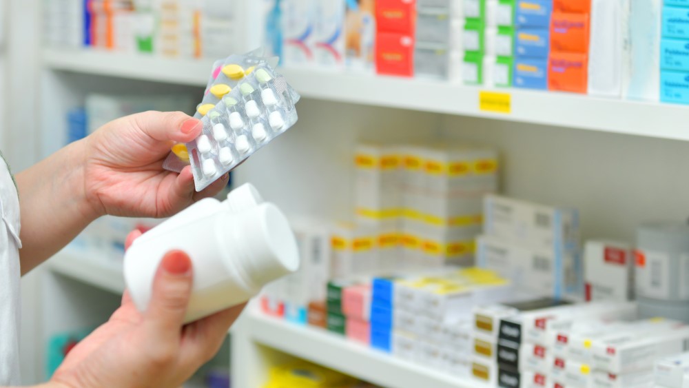 Photo shows pharmacist selecting medicines from shelf