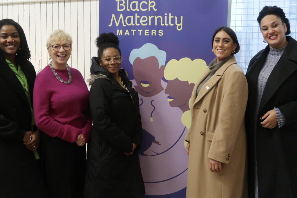 Original members of the collaborative grouped in front of a Black Maternity Matters banner