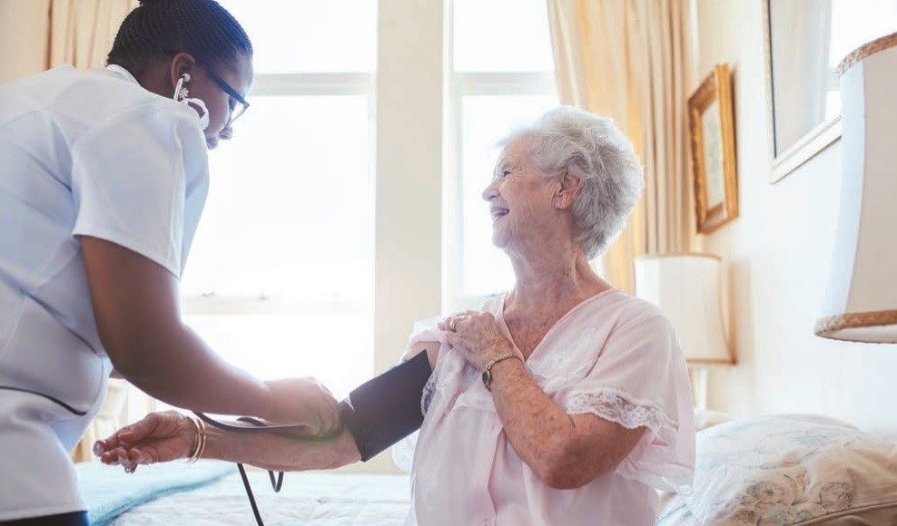 Care home resident having blood pressure checked